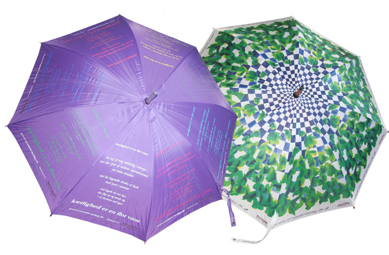 På den violette paraply står Marianne Larsens digt: da jeg så mig omkring i morges/ var der spor af nattens stjernehimmel/ på mine vinduer/ mit liv begyndte straks at kæle/ med lyset i værelset/ ord legede de var kys/ der fløj op og øvede sig/ i at komme ned igen // kærlighed er en flot vane. Paraplyen med bladene på, er designet af kunstneren, Peter Lunding, som også har lavet den lille Græspris-statuette til Poesiens Dag.