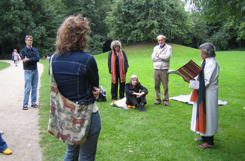 Aase Schmidt (med langt tørklæde) Susanne Jorn (siddende) og Erik Stinus (stående i lyst tøj) lytter til Sara Mathai Stinus, som læser op.